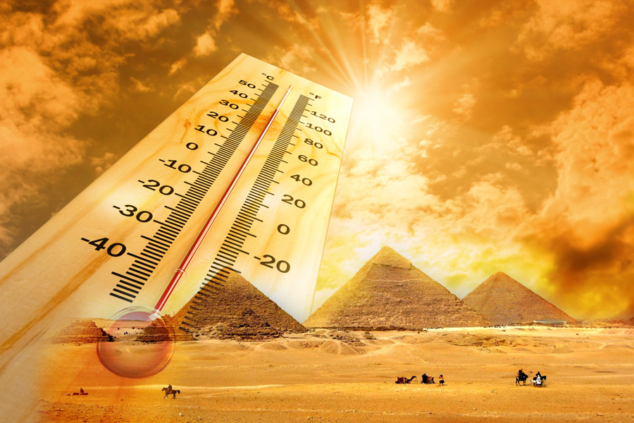 Градусник на фоне яркого солнца и пирамид в Египте. Аптечка туриста в Египте