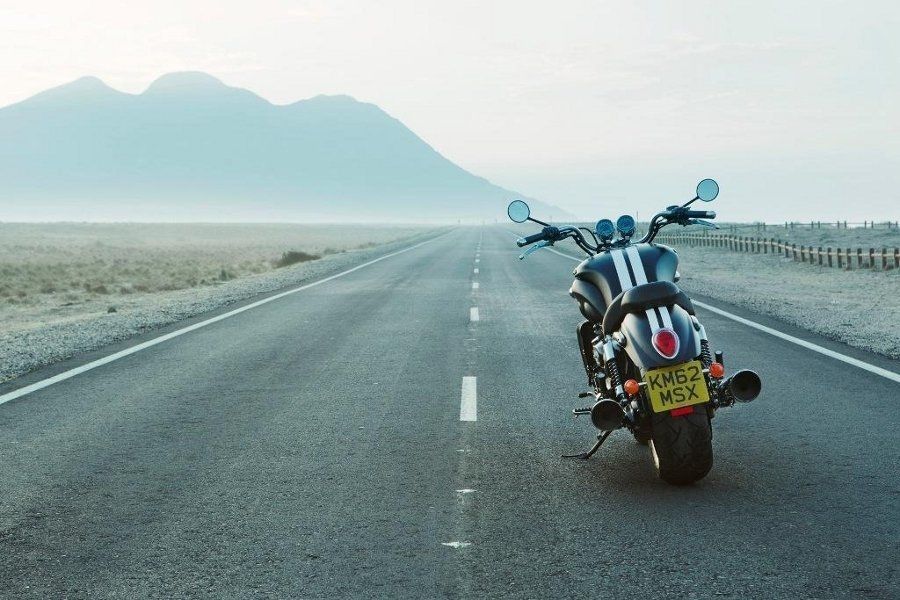 Мотоцикл по среди пустой дороги в пустыне