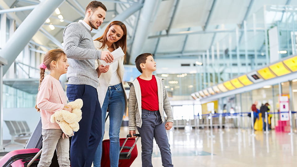 Семья из мужчины, женщины и двух детей в аэропорту